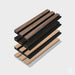 Stack of wooden and black slats on a gray surface with a white background